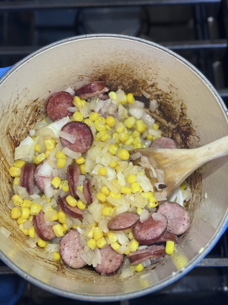 Meanwhile, heat the remaining 1 tablespoon oil in a large saucepan over medium-high heat. Add the sausage and cook just until browned, about 4 minutes. Add the remaining 2 cups onions, the corn, salt, and pepper. Cook, stirring often, until the onions are softened, about 4 minutes.

Add the remaining 6 cups stock and squash puree, and bring to a boil. Reduce the heat to medium-low, cover, and simmer for 20 minutes, stirring occasionally and skimming any fat that rises to the surface.