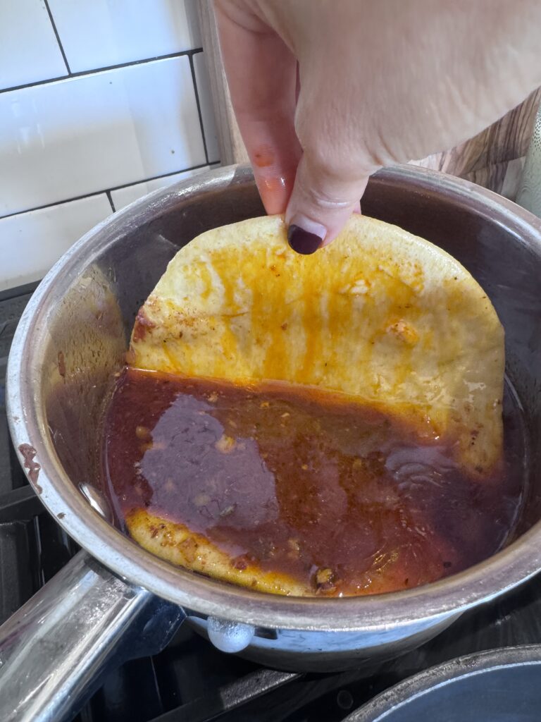 Heat a large griddle or skillet over medium heat and lightly coat it with oil. Dip a corn tortilla into the birria sauce, then place it on the hot pan. Quickly add some shredded meat, cheese, chopped onion, and cilantro on top. 

Fold the tortilla in half and fry for a few minutes until the bottom is crispy and browned. Flip it over and cook until the other side is also crispy and browned. Once done, transfer to a plate and serve.