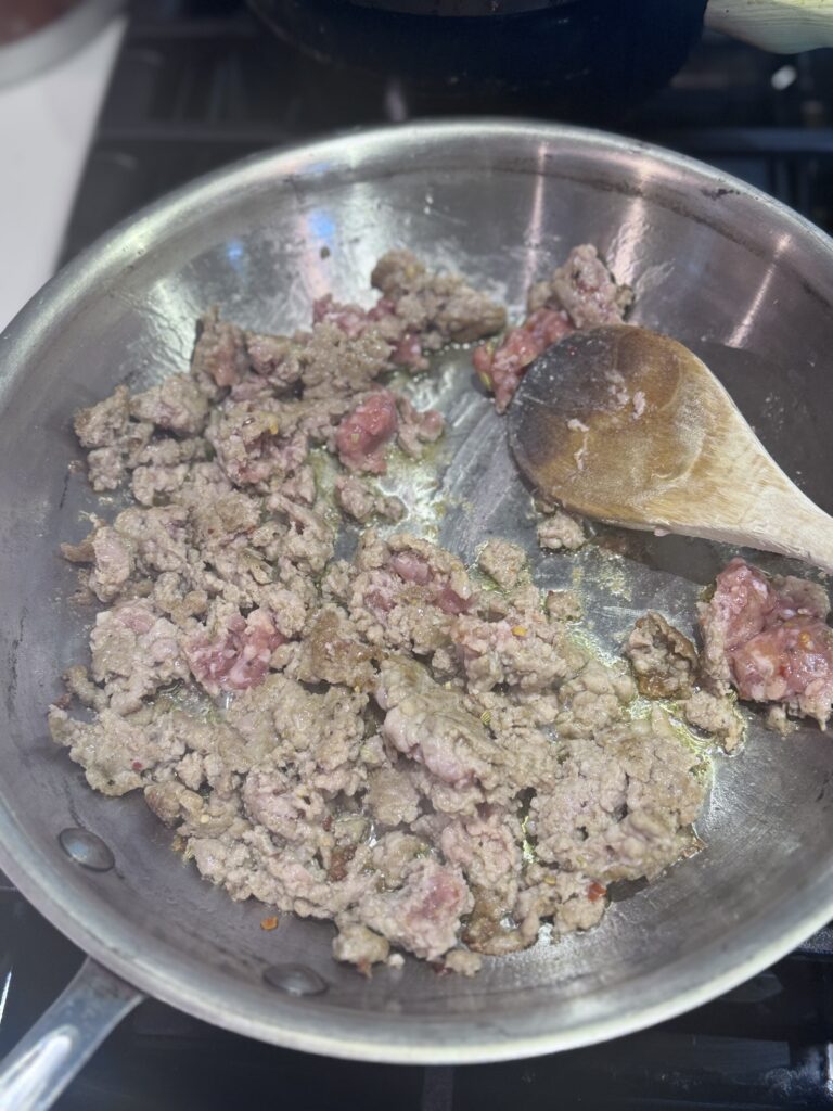 Coat a large saute pan with oil, add the sausage, and bring to medium heat. Cook the sausage until brown, 10-15 minutes. Remove with a slotted spoon and reserve.