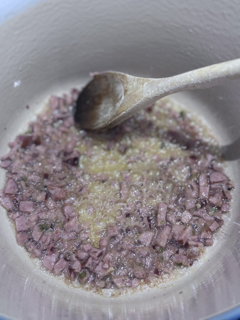 Heat a heavy-bottomed Dutch oven over medium heat. Melt the duck fat (or butter) and add the chopped andouille sausage. Sauté until the sausage is crisp and golden, about 5-6 minutes, stirring frequently.