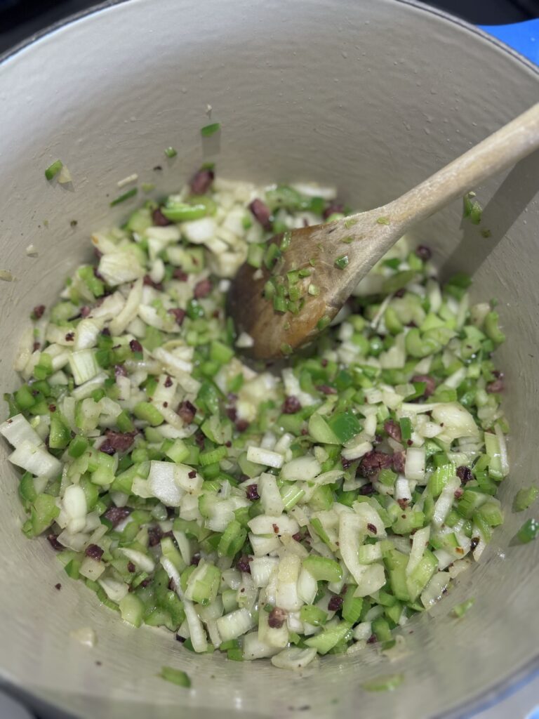 Add the onions, celery, and green bell pepper to the Dutch oven. Cook until tender but still slightly firm, about 5 minutes. Stir occasionally, ensuring nothing sticks to the pan.