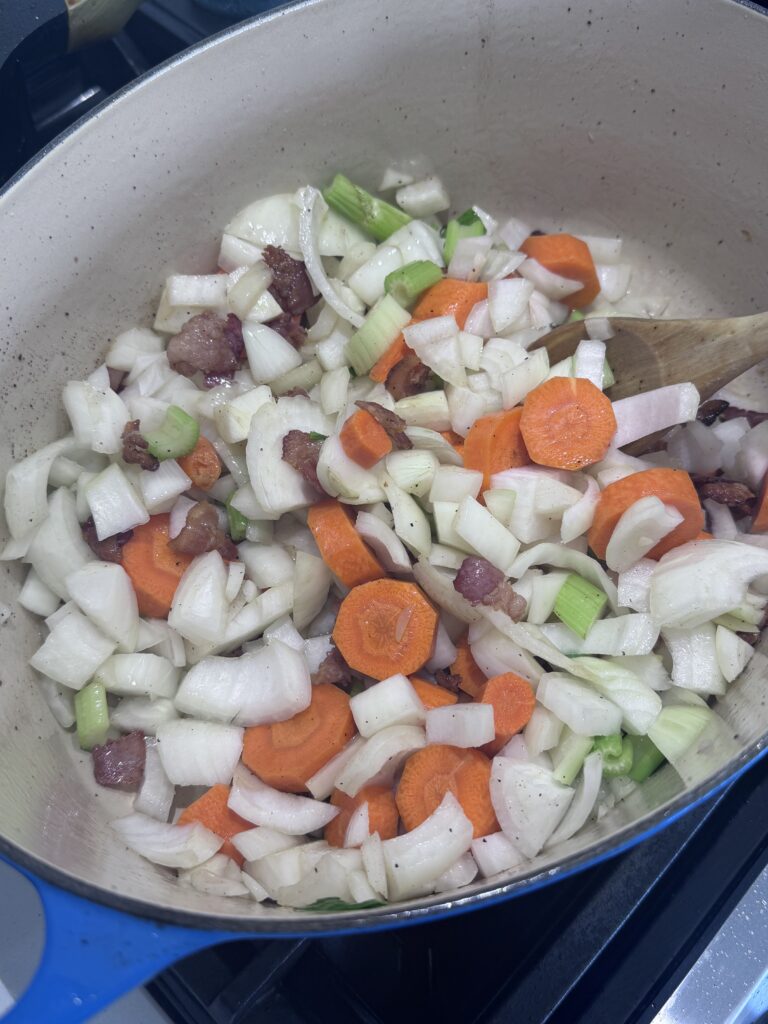 Pour off excess fat from the pot. Add bacon and cook until browned and crisp, about 8 minutes. Stir in onions, carrots, celery, and salt; sauté until softened, about 8–10 minutes.

Add garlic, rosemary, and thyme, cooking until fragrant. Stir in flour and tomato paste, cooking for 1 minute.