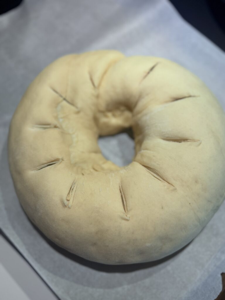 Uncover the risen cake. Using kitchen scissors, make seven ¼-inch deep cuts around the top of the dough to create venting.